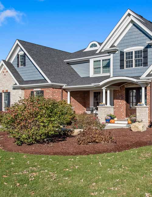 Front law view of brick and blue siding home